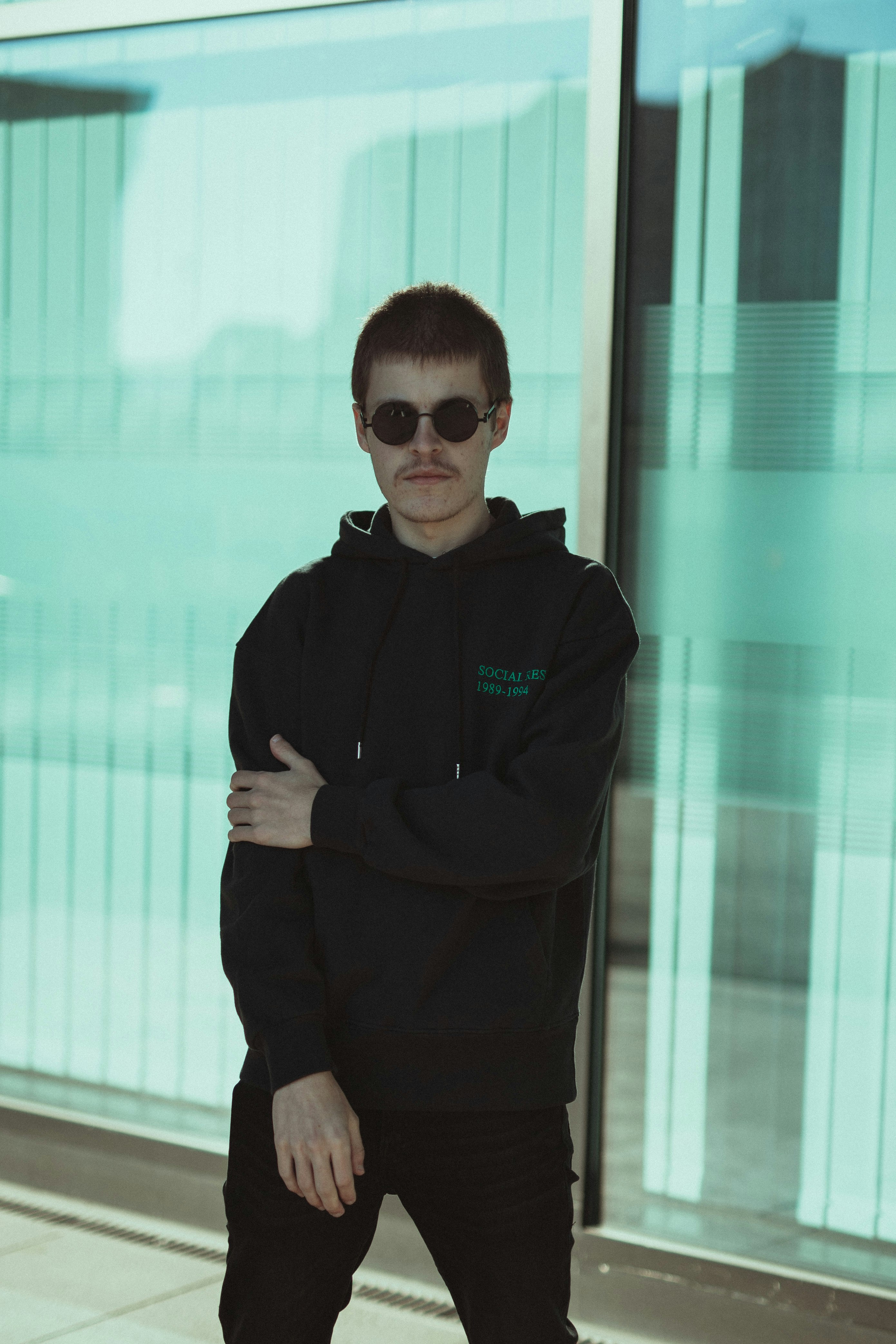 man in black jacket standing near glass wall